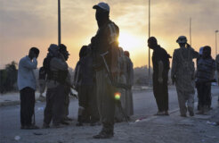 Fighters of the Islamic State of Iraq and the Levant (ISIL) stand guard at a checkpoint in the northern Iraq city of Mosul