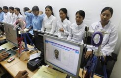 Migrant workers heading for Middle East countries have their picture taken for their passport at the immigration office in Tangerang