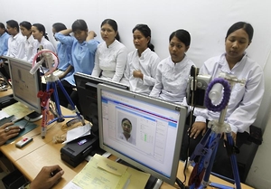 Migrant workers heading for Middle East countries have their picture taken for their passport at the immigration office in Tangerang