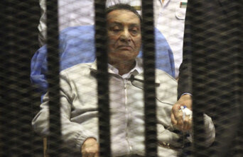 Egypt's ousted President Mubarak sits inside a dock at the police academy on the outskirts of Cairo