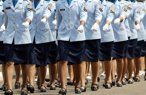 Women in uniform march during a ceremony