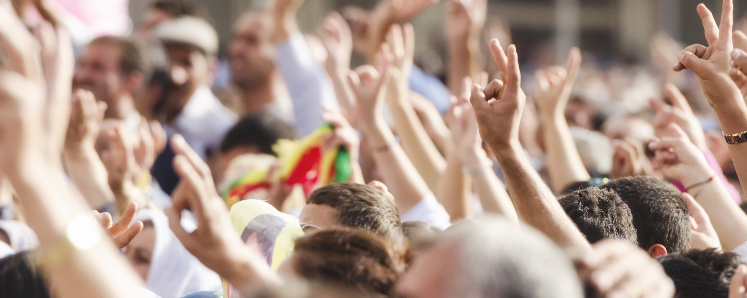Crowds making peace sign at political rally