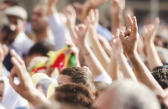 Crowds making peace sign at political rally
