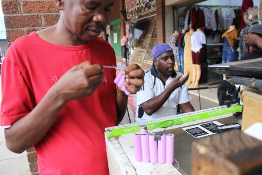 Phillip December scrutinising batteries of a power bank