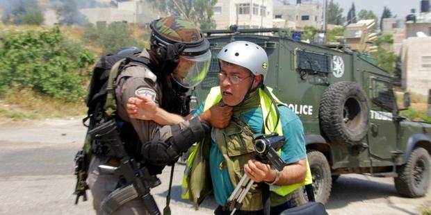Bilal Tamimi being attacked by an Israeli soldier at a protest in Nabi Saleh in May 2013.  © Tamimi Press