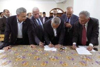 Head of the Hamas government Ismail Haniyeh and senior Fatah official Azzam Al-Ahmed sign a reconciliation agreement in Gaza City