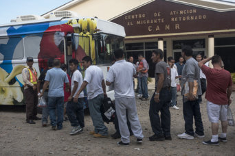 Returned migrants board a bus to Tegucigalpa in front the Center for Returned Migrants, San Pedro Sula airport, Honduras, September 2014. © 2014 Stephen Ferry for Human Rights Watch