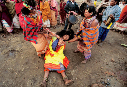 A \'witch\' is being \'cured of evil possession\' during a ceremony.