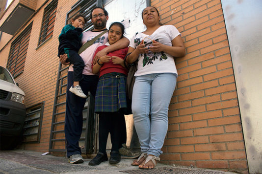 Lorena Meca’s family in front of the squat building they were living in. Now it has been sealed by the bank.