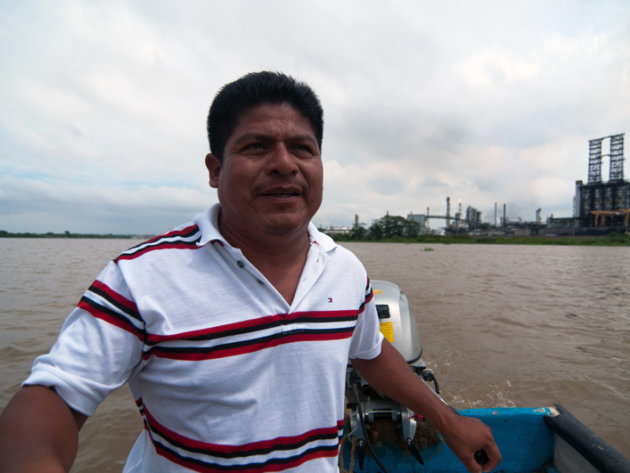 Juan Luis Francisco in a boat on the Coatzacoalcos river with the pet coke processing plant behind him. Juan Luis Francisco in a boat on the Coatzacoalcos river with the pet coke processing plant behind him.