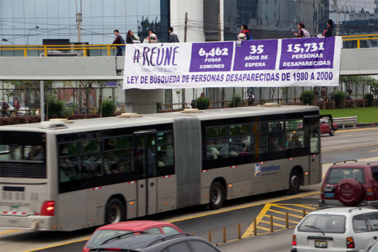 Activist display a sign in a street in Lima to ask for a legal search for the disappeared