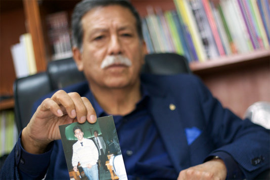 Julio César Jerí showing a photo of his disappeared son César Raphael Jerí.