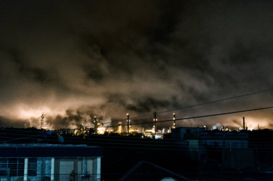 The glare produced by the burners of the plant chimneys is seen from several kilometers away at night.