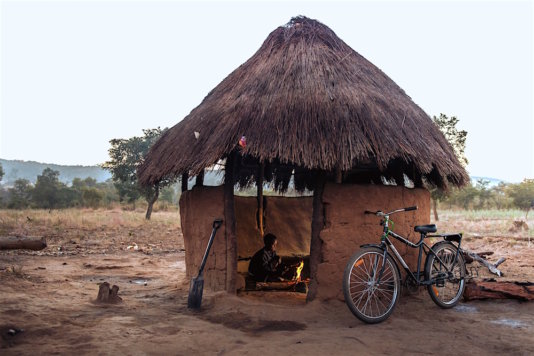 Tamara, a student in Zambia, cooks breakfast in the early dawn before she heads to school on her Buffalo Bicycle. Often girls must complete many hours of domestic chores before school.