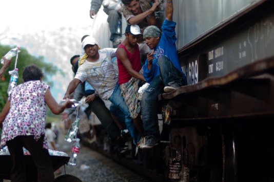 The Patronas handing the lunches to the migrants as the trains pass through La Patrona The Patronas handing the lunches to the migrants as the trains pass through La Patrona