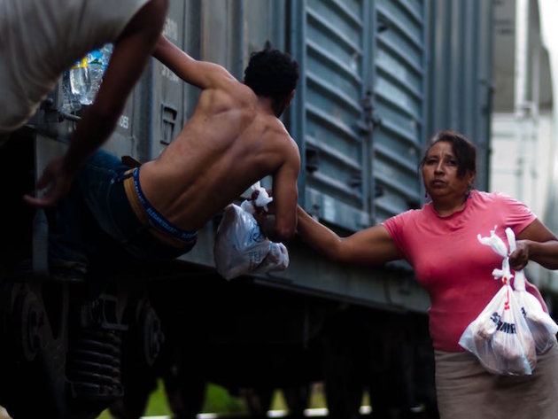 The Patronas handing the lunches to the migrants as the trains pass through La Patrona The Patronas handing the lunches to the migrants as the trains pass through La Patrona