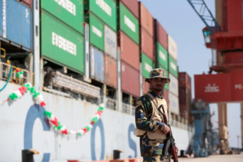 A soldier stands guard beside the Cosco Wellington, the first container ship to depart after the inauguration of the China Pakistan Economic Corridor port in Gwadar