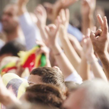 Crowds making peace sign at political rally