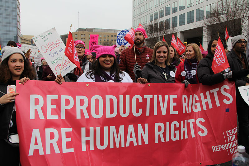 Group of female protestors holding banner that reads 'reproductive rights are human rights'.