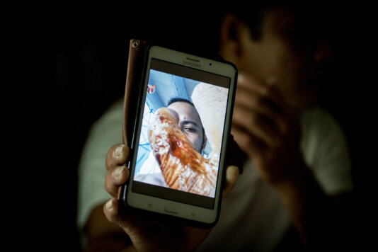 Marwen* was trafficked onto a Taiwanese fishing vessel in 2016. Pictured here in a Taipei shelter for trafficked workers, he shows pictures of injuries he sustained and living conditions aboard the fishing vessel. He was made to continue working for days after his accident and has suffered permanent damage to his hand. Workers report being coerced into signing contracts written in Chinese that they are unable to read. They must borrow money from brokers to cover travel, medical and administration costs. This is repaid from their meagre salaries over the course of their contracts, which can last for years. As such, they are victims of debt-bondage and feel compelled to continue working, regardless of how they are treated or the condition on board the boats. Many fear for the safety of their dependants at home, who are sometimes threatened if debts are not paid. RS24006_IMGL0501