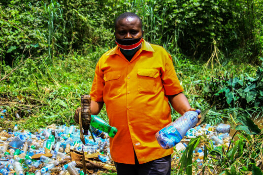 Pastor Isaack Isumael holds plastic bottles he removed from Ruaka River in Nairobi on 24th August 2020 during a cleanup drive.