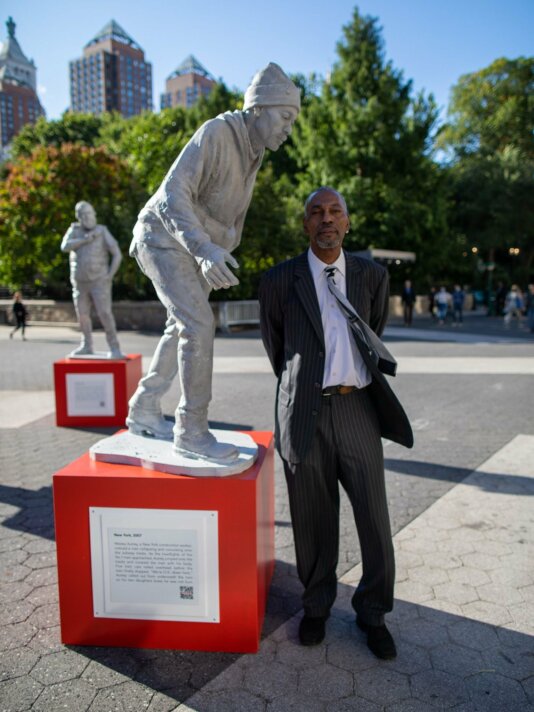 Wesley Autrey, a local New York hero, stands next to his Protector statue
