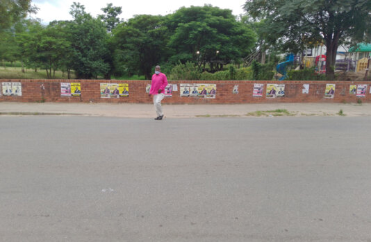 A man walks past by-election campaign posters in the city of Mutare, eastern Zimbabwe on March 26, 2022.