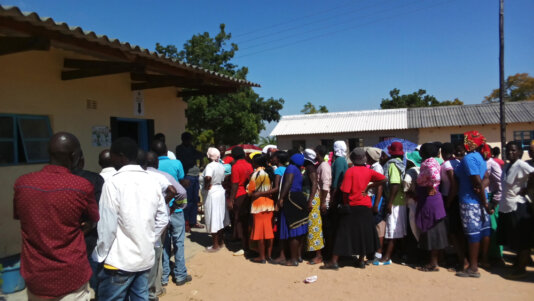 People jostle to vote at a polling station in rural Zimbabwe in 2018.
