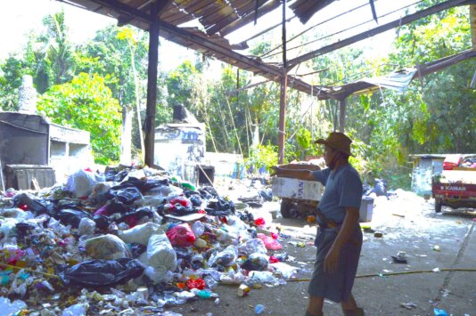 Babe Idin demonstrating how piles of rubbish are recycled at his organisation\'s facility.