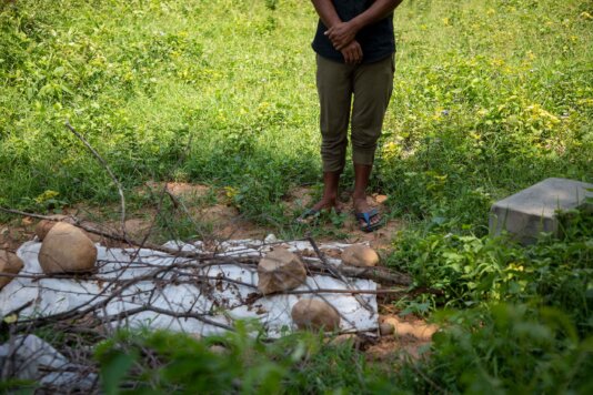 A Rohingya refugee offers prayers at the grave of Umul Habiba, a 5 month old infant.