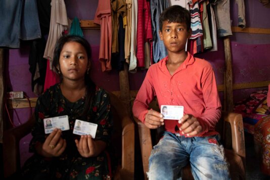 Rohingya children show their detained parents\' UNHCR issued ID  cards.